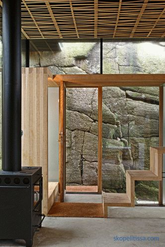 Ház átlátszó falakkal napos sziklás partján, Sandefjord, Norvégia